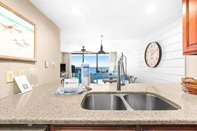 a kitchen sink with a view of a living room at One Seagrove Place 1004 in Santa Rosa Beach