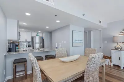 a kitchen and dining room with a wooden table and chairs at One Seagrove Place 0807 in Santa Rosa Beach