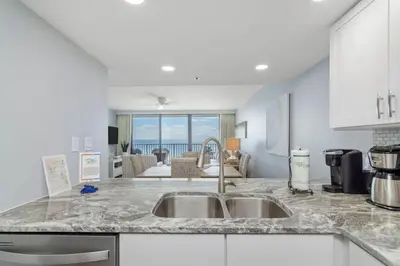 a kitchen with a sink and a living room at One Seagrove Place 0807 in Santa Rosa Beach