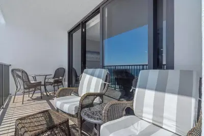 a group of chairs and tables on a balcony at One Seagrove Place 0807 in Santa Rosa Beach