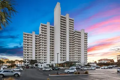 a large white building with cars parked in a parking lot at One Seagrove Place 0807 in Santa Rosa Beach