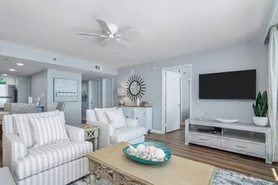a living room with white furniture and a flat screen tv at One Seagrove Place 0807 in Santa Rosa Beach