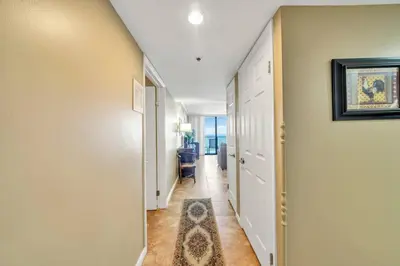 a hallway with white walls and a rug on the floor at One Seagrove Place 1408 in Santa Rosa Beach
