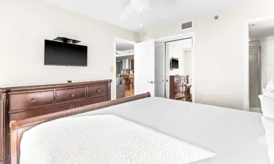 a bedroom with a bed and a tv on a wall at One Seagrove Place 1408 in Santa Rosa Beach