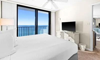 a white bedroom with a large bed and a television at One Seagrove Place 1208 in Santa Rosa Beach