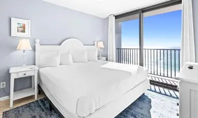 a white bedroom with a large bed and a balcony at One Seagrove Place 0902 in Santa Rosa Beach