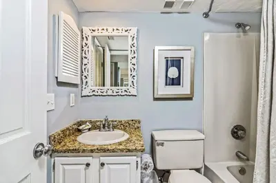 a bathroom with a sink and a toilet and a mirror at One Seagrove Place 0902 in Santa Rosa Beach