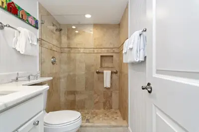 a bathroom with a shower with a toilet and a sink at One Seagrove Place 1303 in Santa Rosa Beach