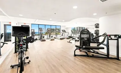 a gym with several tread machines and a flat screen tv at One Seagrove Place 1303 in Santa Rosa Beach