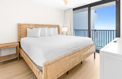 a bedroom with a large bed and a balcony at One Seagrove Place 1203 in Santa Rosa Beach