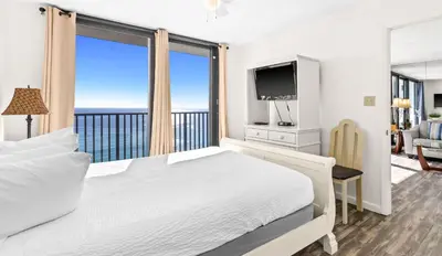 a bedroom with a large bed and a balcony at One Seagrove Place 1306 in Santa Rosa Beach