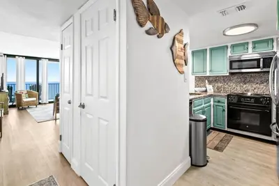 a kitchen with green cabinets and an open door at One Seagrove Place 1407 in Santa Rosa Beach