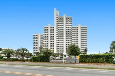 a large white apartment building with a parking lot at One Seagrove Place 1407 in Santa Rosa Beach