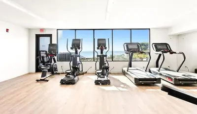 a gym with a row of exercise bikes in a room at One Seagrove Place 1503 in Santa Rosa Beach