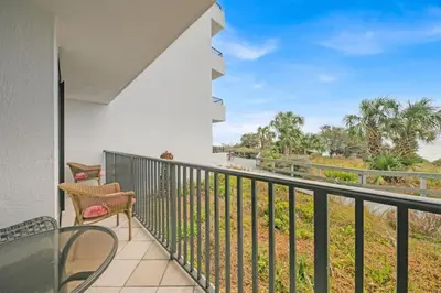 a balcony with a table and chairs and a view of the water at One Seagrove Place 0107 in Santa Rosa Beach