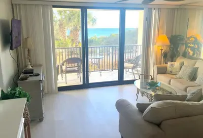 a living room with a couch and a table and a balcony at One Seagrove Place 0107 in Santa Rosa Beach