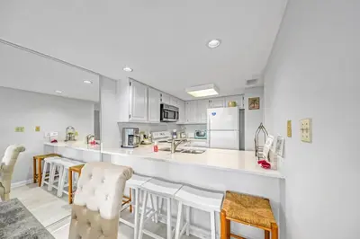 a kitchen with a counter and stools in a room at One Seagrove Place 0107 in Santa Rosa Beach