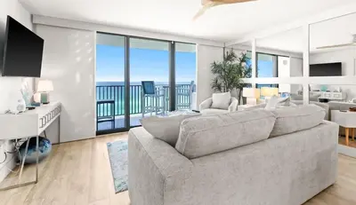 a living room with a large couch and a balcony at One Seagrove Place 1106 in Santa Rosa Beach