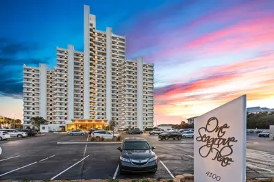 a parking lot with a car parked in front of a large building at One Seagrove Place 1106 in Santa Rosa Beach