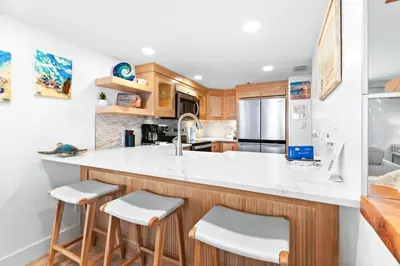 a kitchen with white countertops and wooden cabinets at One Seagrove Place 1106 in Santa Rosa Beach
