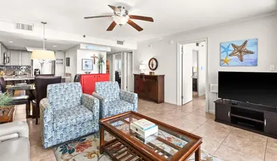 a living room with two chairs and a flat screen tv at One Seagrove Place 1507 in Santa Rosa Beach