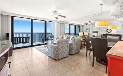 a dining room and living room with a view of the ocean at One Seagrove Place 1507 in Santa Rosa Beach
