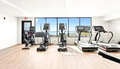a gym with a row of cardio machines at One Seagrove Place 0201 in Santa Rosa Beach