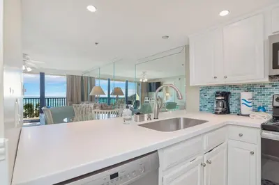 a kitchen with white cabinets and a view of the ocean at One Seagrove Place 0201 in Santa Rosa Beach