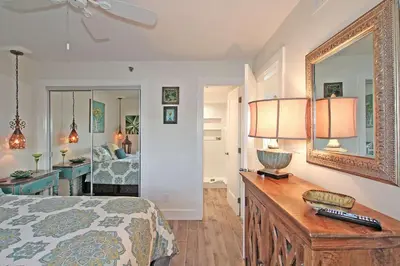 a bedroom with a bed and a table with a mirror at One Seagrove Place 0205 in Santa Rosa Beach