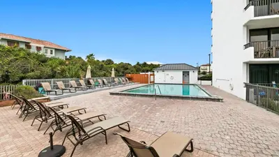 a patio with chairs and a swimming pool at One Seagrove Place 0205 in Santa Rosa Beach