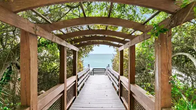 a wooden bridge over a boardwalk leading to the ocean at One Seagrove Place 0205 in Santa Rosa Beach