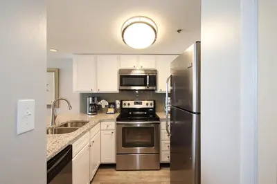 a kitchen with white cabinets and a stainless steel refrigerator at One Seagrove Place 0403 in Santa Rosa Beach