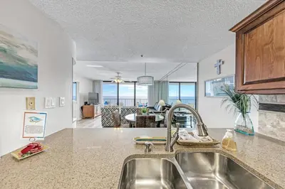 a kitchen with a sink and a living room at One Seagrove Place 1508 in Santa Rosa Beach