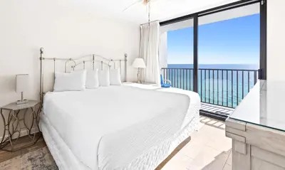 a white bedroom with a large bed and a balcony at One Seagrove Place 1508 in Santa Rosa Beach