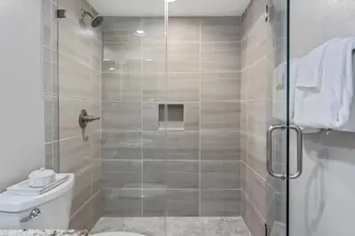 a bathroom with a glass shower with a toilet at One Seagrove Place 0202 in Santa Rosa Beach
