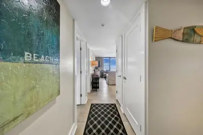 a hallway with white walls and a black and white rug at One Seagrove Place 0401 in Santa Rosa Beach