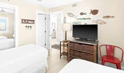 a bedroom with a flat screen tv and two beds at One Seagrove Place 0401 in Santa Rosa Beach