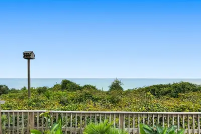 a fence with a light pole on top of a hill at One Seagrove Place 1906 in Santa Rosa Beach