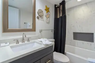 a bathroom with a sink and a toilet and a mirror at One Seagrove Place 1706 in Santa Rosa Beach