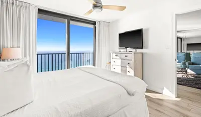 a white bedroom with a bed and a large window at One Seagrove Place 1706 in Santa Rosa Beach