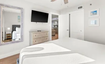 a white bedroom with a bed and a mirror at One Seagrove Place 1201 in Santa Rosa Beach