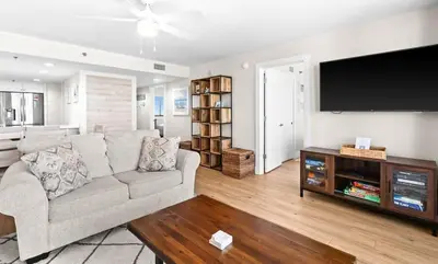 a living room with a couch and a flat screen tv at One Seagrove Place 1201 in Santa Rosa Beach