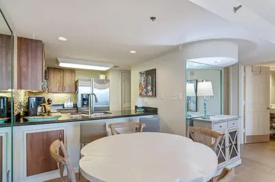 a kitchen with a white table and chairs in it at One Seagrove Place 0105 in Santa Rosa Beach