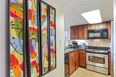 a kitchen with a refrigerator with a painting on it at One Seagrove Place 0105 in Santa Rosa Beach