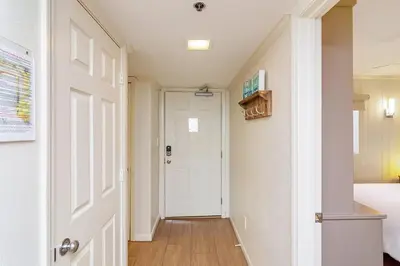 a hallway with a white door and a bedroom at One Seagrove Place 0105 in Santa Rosa Beach