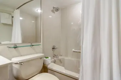 a bathroom with a white toilet and a shower at One Seagrove Place 0105 in Santa Rosa Beach