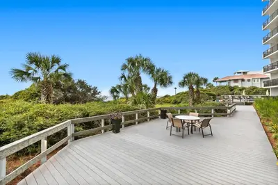 a wooden deck with a table and chairs on it at One Seagrove Place 1206 in Santa Rosa Beach