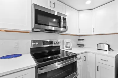 a kitchen with a stove and a microwave at One Seagrove Place 1008 in Santa Rosa Beach