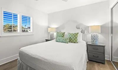 a white bedroom with a large bed and two windows at One Seagrove Place 0207 in Santa Rosa Beach