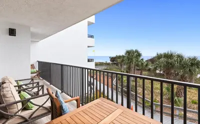 a balcony with a wooden table and a view of the ocean at One Seagrove Place 0207 in Santa Rosa Beach